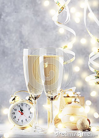 Two champagne glasses and christmas decoration over gray golden bokeh background. Happy New Year Celebration. Selective focus and Stock Photo