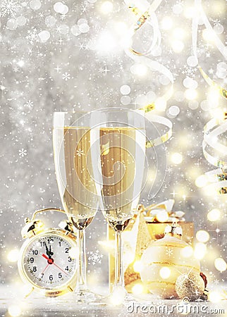 Two champagne glasses and christmas decoration over gray golden bokeh background. Happy New Year Celebration. Selective focus and Stock Photo