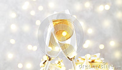 Two champagne glasses and christmas decoration over gray golden bokeh background. Happy New Year Celebration. Selective focus and Stock Photo