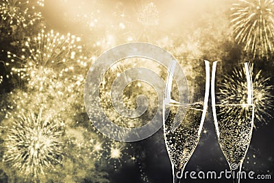 two champagne glasses ready to bring in the New Year - holiday lights and fireworks in the background Stock Photo