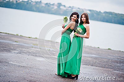 Two charmed girls bridesmaids on green dress Stock Photo