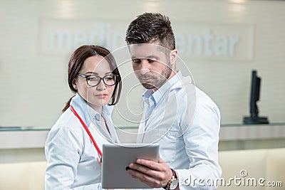 Two cheerful doctors using a digital tablet. Stock Photo