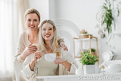 two cheerful pretty sisters looking at Stock Photo