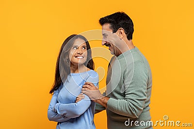 Two cheerful senior man and woman, share light-hearted moment, laughing and looking at each other Stock Photo