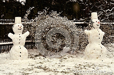 Two cheerful snowmen standing in the garden Stock Photo