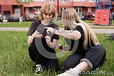 Two cheerful teenage girls send a photo to the social network. Choose content Stock Photo