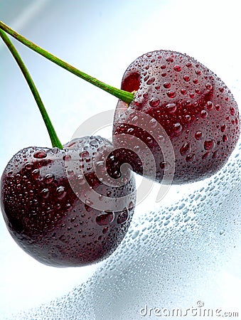 Two cherries with waterdrops on light blue surface Stock Photo