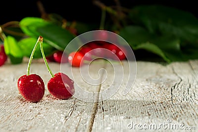 Two cherries on a wooden blurred background Stock Photo