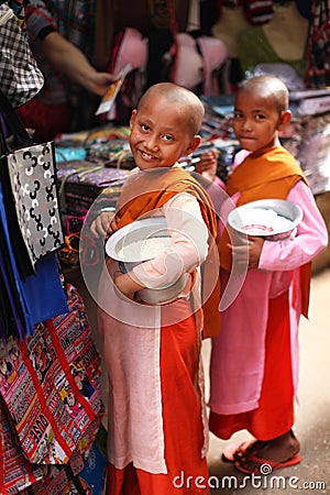 Two child nuns with alms bowls filled with rice, Burma Editorial Stock Photo