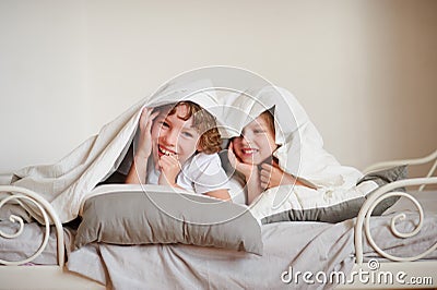 Two children, brother and sister, squirmy on the bed in the bedroom. Stock Photo