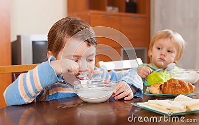 Two children eating dairy breakfast Stock Photo