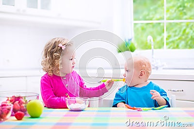 Two children eating yoghurt Stock Photo