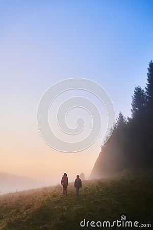 Two children going for a walk on a foggy morning among the trees. View in the Beskid Hills in Poland Stock Photo