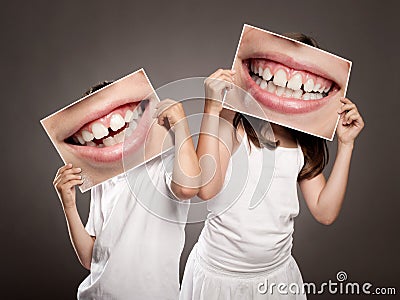 Two children holding a picture of a mouth smiling Stock Photo