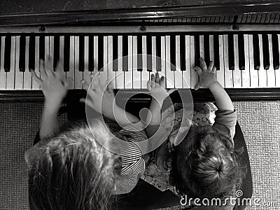 Two children play music on piano Stock Photo