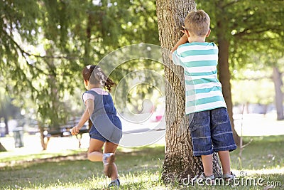 Two Children Playing Hide And Seek In Park Stock Photo