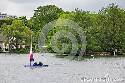Two children practice sailing on a Spring day in South Norwood l Stock Photo
