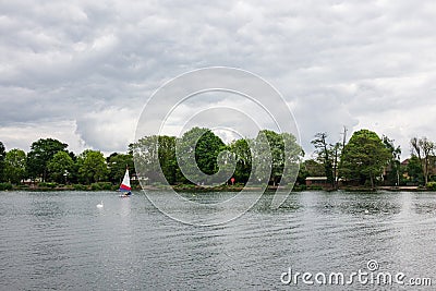 Two children practice sailing on a Spring day in South Norwood l Stock Photo