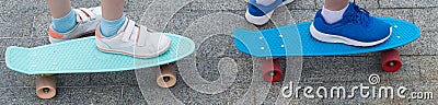 Two children`s skateboards, close-ups, with standing feet on them Stock Photo