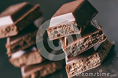 Two chocolate buildings on a dark background. energy and sugar. Broken bar. Chocolate blocks stack Stock Photo