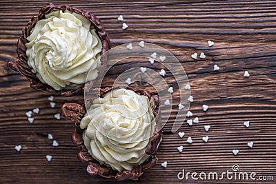 Two chocolate desserts filled with white cream on wooden table, dessert with white hearts for valentines day Stock Photo