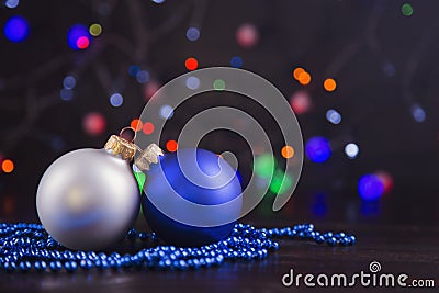 Two Christmas balls and beads with garland lights on colorful bo Stock Photo