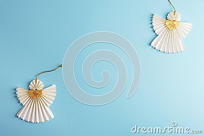 Two Christmas paper angels on light blue background. Holiday concept. Top view, flat lay, copy space Stock Photo