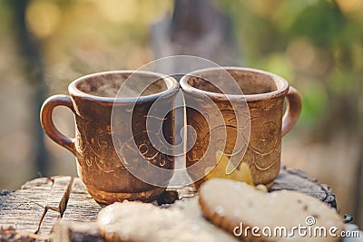 Two Clay Rural Cup with Hot Beverage are on the Wooden Stumb with Autumnal Leaves.Nature Background.Selective Focus Stock Photo