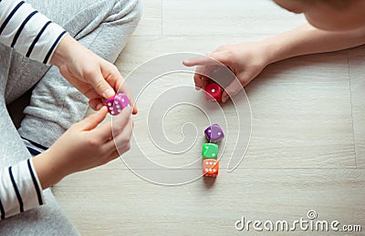 Two clever children study mathematics playing with dices on the floor Stock Photo