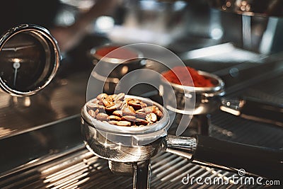 Two coffee holders one with fresh ground coffee another with roasted beans standing on coffee machine close up Stock Photo