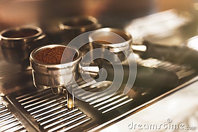 Two coffee holders one with ground coffee near professional coffee machine close up, barista tools Stock Photo