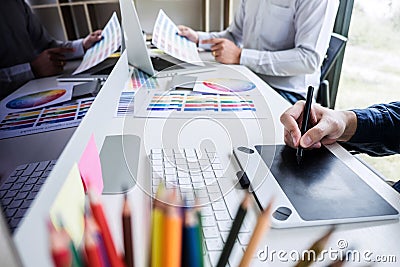 Two colleague creative graphic designer working on color selection and color swatches, drawing on graphics tablet at workplace wi Stock Photo