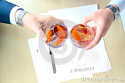 Two colleagues celebrate signing a contract with Whisky Stock Photo