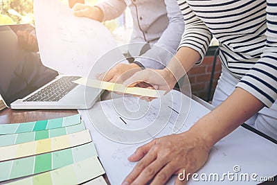 Two colleagues interior Creative creativity graphic designer working with graphics laptop, blueprint and colour chart Stock Photo