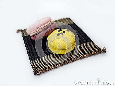 Two colorful macaroons lay on the wooden mat Stock Photo