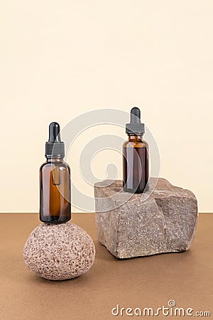 Two cosmetic brown glass bottles with pipette on stones, beige brown background. Natural Organic Spa Cosmetic concept Stock Photo