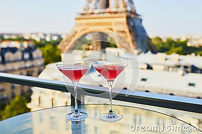 Two Cosmopolitan cocktails in traditional martini glasses with view to the Eiffel tower, Paris, France Stock Photo