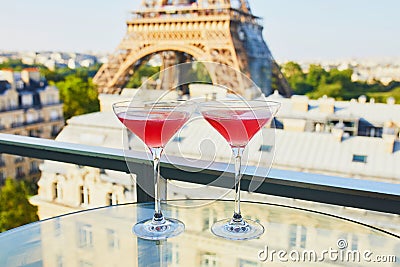 Two Cosmopolitan cocktails in traditional martini glasses with view to the Eiffel tower, Paris, France Stock Photo