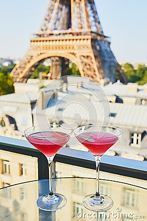 Two Cosmopolitan cocktails in traditional martini glasses with view to the Eiffel tower, Paris, France Stock Photo