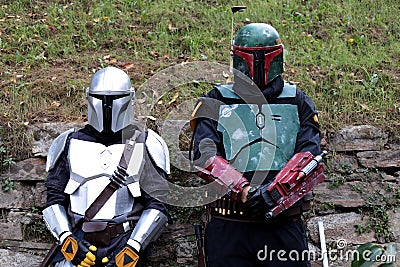 Two Cosplayers dressed as The Mandalorian and Boba Fett, characters from the Star Wars film series at the Lucca Comics and Games. Editorial Stock Photo