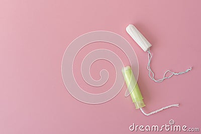 Two cotton tampons with light green applicator and without applicator on a pink background. Hygienic types of tampons. Stock Photo