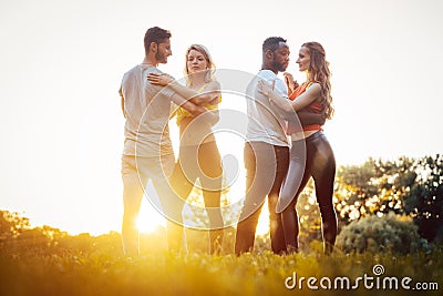 Two couples dancing kizomba during sunset in a park Stock Photo