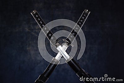 Two crossed katanas with partially drawn blades Stock Photo