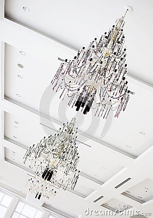 Two crystal chandeliers hanging on white ceiling Stock Photo