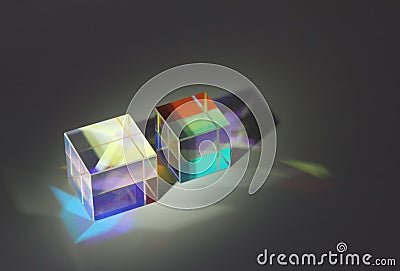 Two cubic glass prism refract light into different colors and cast shadows Stock Photo