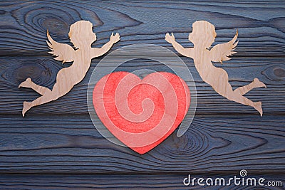 Two cupids and a red heart made of wood texture. Stock Photo