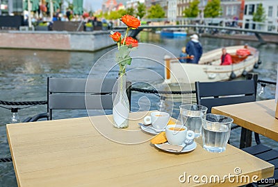 Two cups of coffee on cafÃ© table on beautiful Dutch terrace by canal water, Leiden, Netherlands Stock Photo