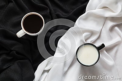 Two cups of coffee and milk on the black or white fabric. Top view. Stock Photo