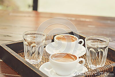 Two cups of coffee placed on a wooden tray selective focus. Stock Photo