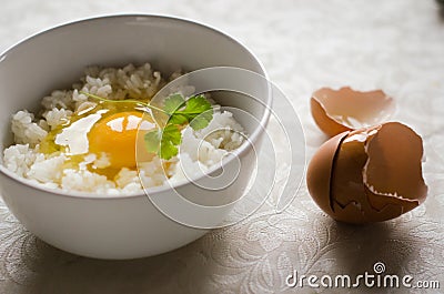 Two cups with fresh egg yolk is on the top of Japanese rice Stock Photo